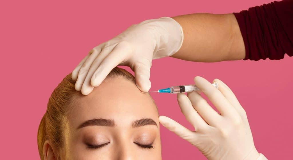 close-up image of a woman receiving an injection in her forehead