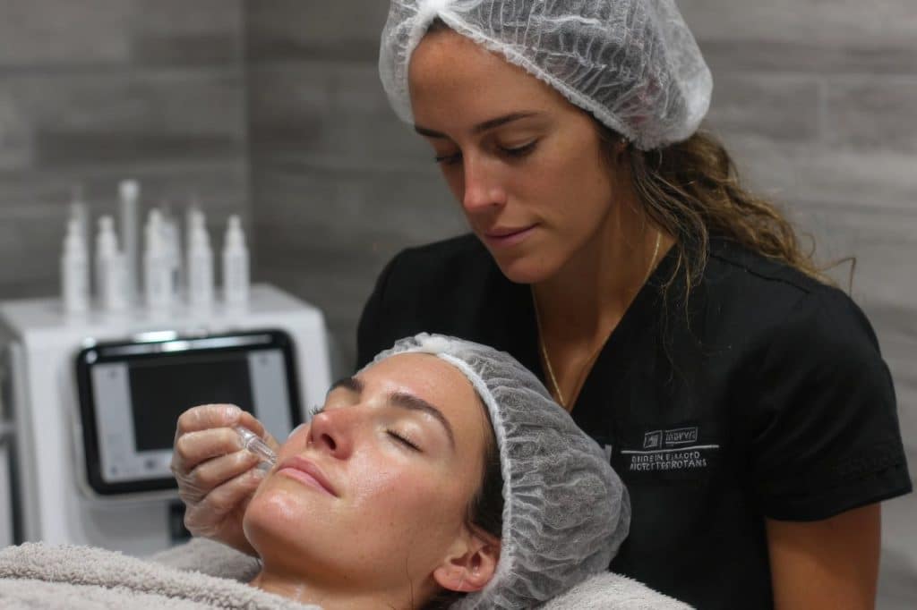 A woman getting her face done by a medical professional