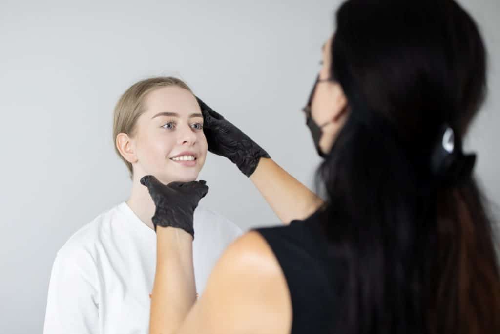 beauty expert examining a client's face