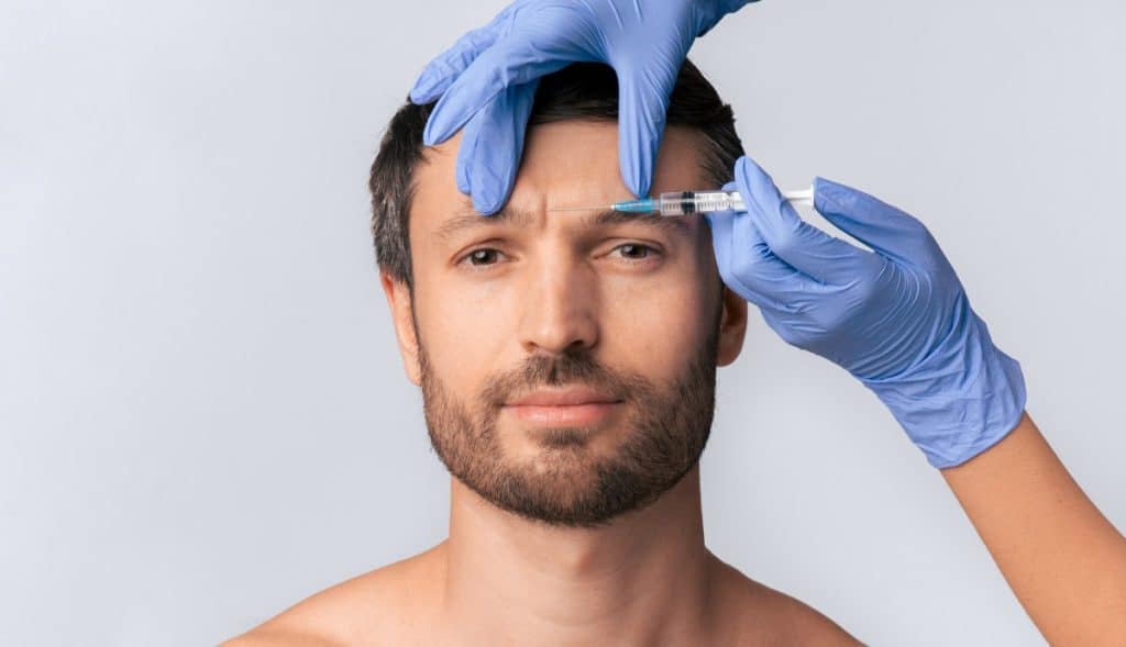 man receives an injection to his forehead
