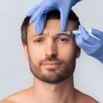 man receives an injection to his forehead