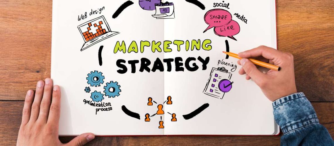 person sketching marketing strategy on white paper
